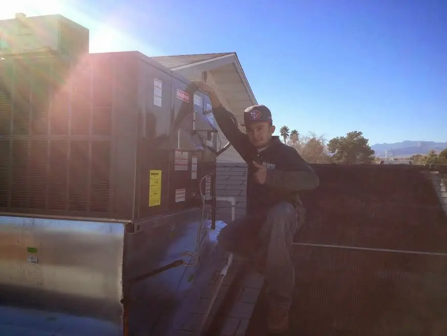 HVAC technician performing Air Duct Repair on a rooftop unit in Coldwater