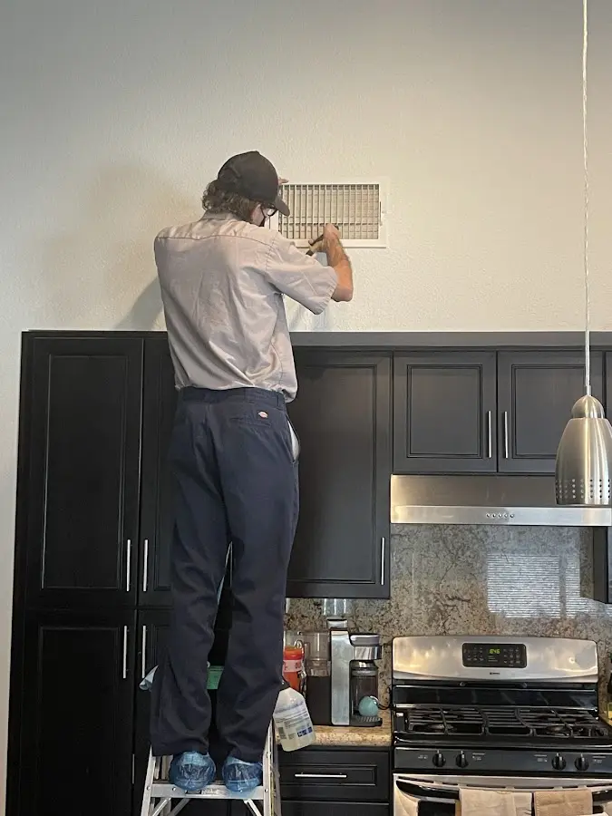 Technician inspecting an air vent during HVAC service in Coldwater